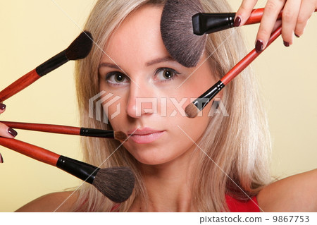 Beautiful young woman make-up brush yellow 9867753