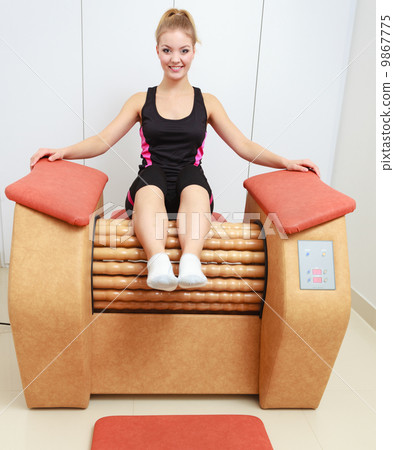 Girl in sportwear on relax massage equipment healthy spa salon 9867775