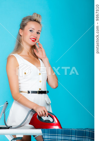 Sexy girl retro style ironing male shirt, woman housewife in domestic role. 9867810
