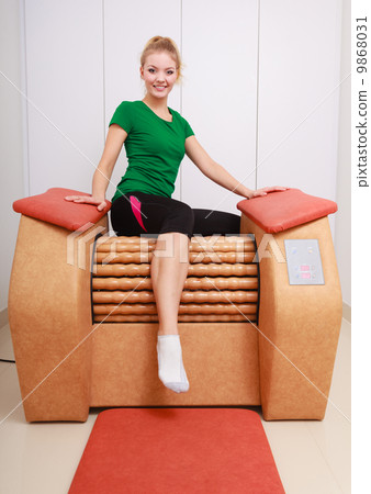 Girl in sportwear on relax massage equipment healthy spa salon Girl in sportwear on relax massage equipment healthy spa salon 9868031