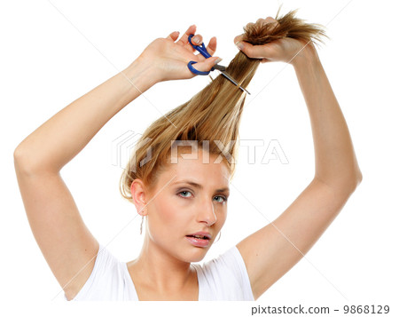Unhappy woman cutting her hair with scissors Unhappy woman cutting her hair with scissors 9868129