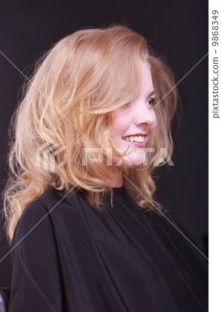 Beautiful smiling girl with blond wavy hair by hairdresser in beauty salon Beautiful smiling girl with blond wavy hair by hairdresser in beauty salon 9868349