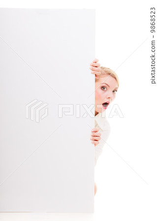 Surprised blonde girl with blank presentation board banner sign. 9868523
