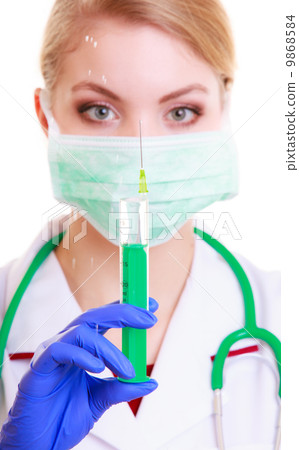 Woman in mask and lab coat. Doctor nurse with syringe. 9868584