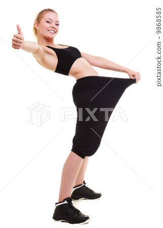 happy woman showing how much weight she lost, big pants 9868585
