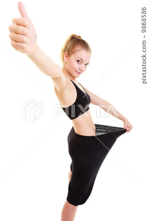 happy woman showing how much weight she lost, big pants 9868586