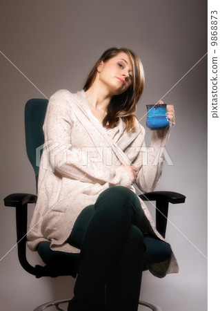 Pretty woman daydreaming while holding a tee cup 9868873