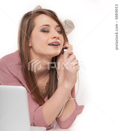 Cute girl with headphones and laptop lying isolated 9869053