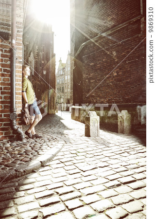 Young man with bag on street, old town Gdansk 9869310