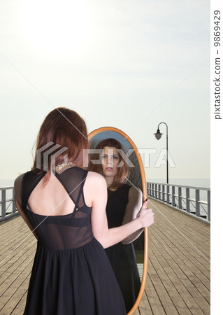 thoughtful woman looks at the reflection in mirror thoughtful woman looks at the reflection in mirror 9869429