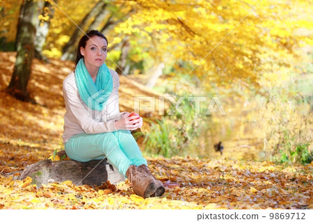 Young girl relaxing in autumnal park. Fall lifestyle concept. Young girl relaxing in autumnal park. Fall lifestyle concept. 9869712