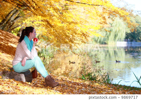 Young girl relaxing in autumnal park. Fall lifestyle concept. Young girl relaxing in autumnal park. Fall lifestyle concept. 9869717