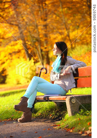 Young girl relaxing in autumnal park. Fall lifestyle concept. Young girl relaxing in autumnal park. Fall lifestyle concept. 9869748