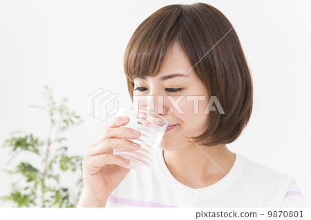 A woman drinking a glass of water 9870801