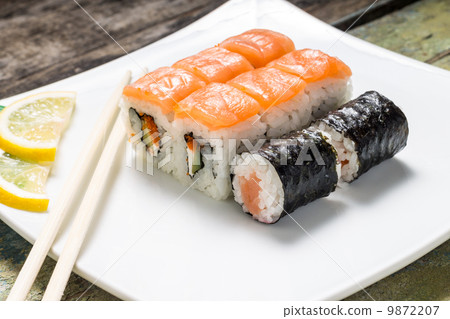 Seafood sushi rolls in white plate with chopsticks and japanese spices 9872207