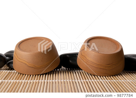 Two turned clay cups, mat and stones 9877784