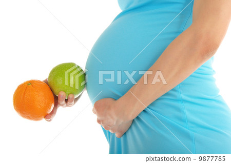 Pregnant woman's belly, apple and orange 9877785