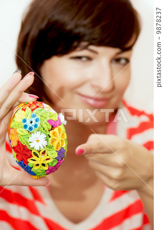 Young woman presents colorful easter egg Young woman presents colorful easter egg 9878237