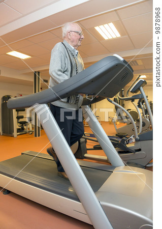 Elderly man exercising on a treadmill Elderly man exercising on a treadmill 9878968