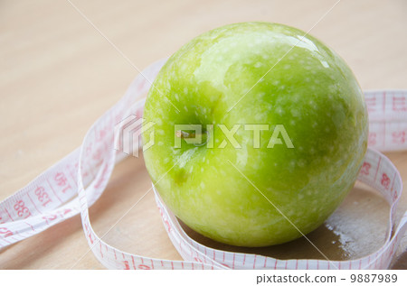 Green apple core and measuring tape. Diet concept Green apple core and measuring tape. Diet concept 9887989