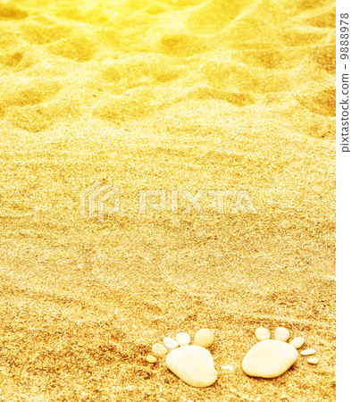footprints of stones on yellow sand on the beach in summer 9888978