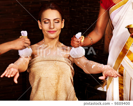 Woman having massage with pouch of rice. 9889400