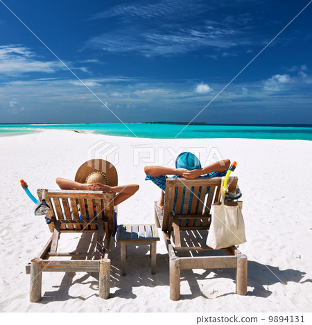 Couple relax on a beach at Maldives Couple relax on a beach at Maldives 9894131