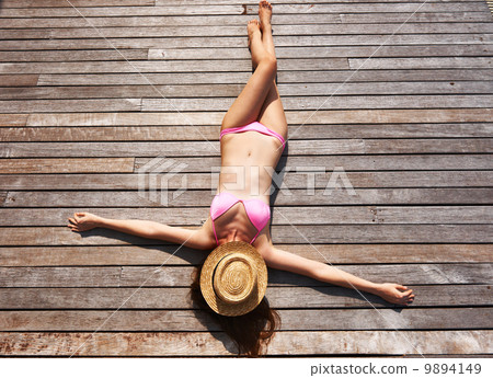 Woman sunbathing lying at deck 9894149