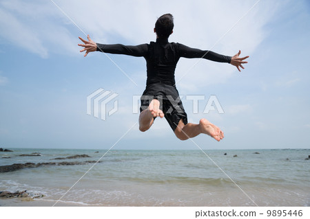Asian man jumping high up into the sky feeling free 9895446