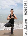 Asian male doing yoga on the beach 9895464