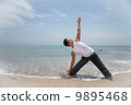 Asian male doing yoga on the beach 9895468
