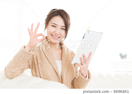 觀看一種片劑的婦女在屋子裡 觀看一種片劑的婦女在屋子裡 9896861