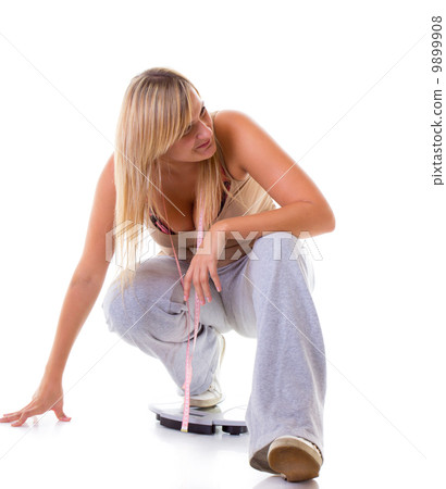 Large woman on scale measuring her weight Large woman on scale measuring her weight 9899908