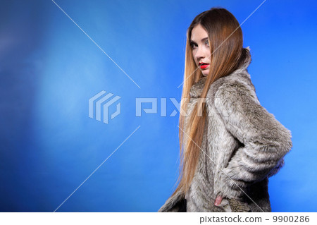 portrait of young woman in fur blue background 9900286
