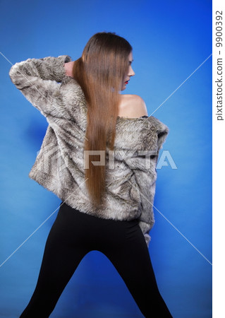 young woman in fur long hair blue background young woman in fur long hair blue background 9900392