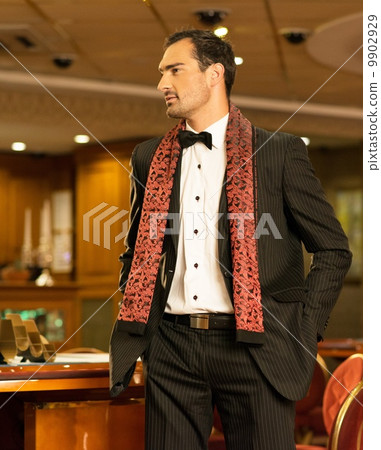 Handsome brunette wearing suit and scarf in luxury interior 9902929