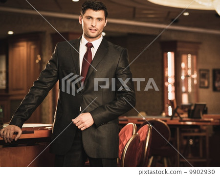 Handsome brunette wearing suit and necktie in luxury interior 9902930