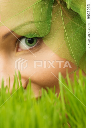 Smiling young woman hiding in a fresh spring grass Smiling young woman hiding in a fresh spring grass 9902933