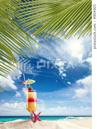 Fresh tropical cocktail on sunny beach in Maldives 9904905