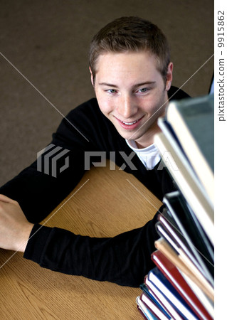 Student Looking At Book Stack Student Looking At Book Stack 9915862