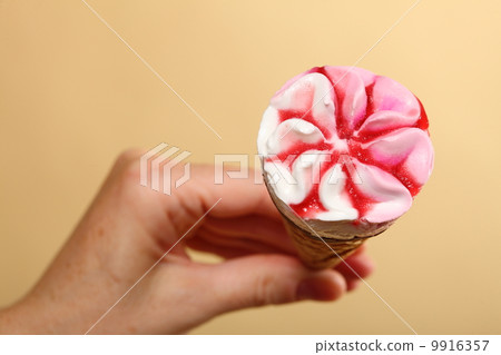 Berry icecream cone in hand on orange 9916357