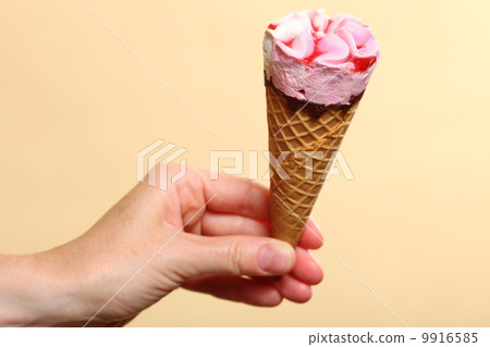 Berry icecream in hand on orange background Berry icecream in hand on orange background 9916585