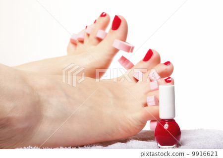 foot pedicure applying red toenails on white 9916621
