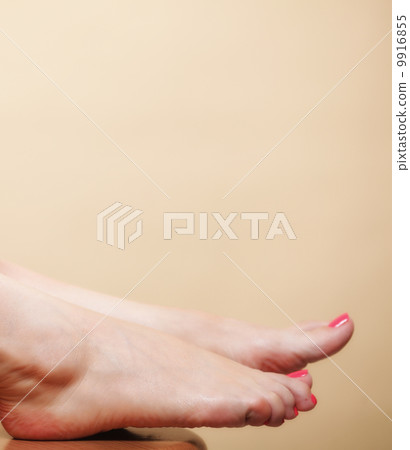 Beautiful woman foot on orange background 9916855
