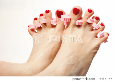 foot pedicure applying red toenails on white 9916966