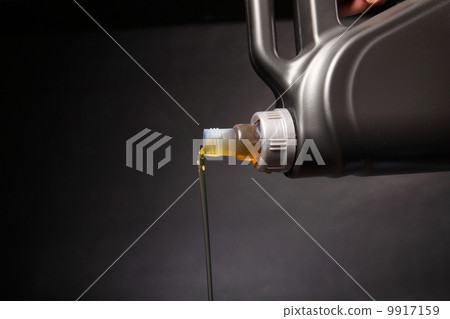 Can with car engine oil pouring black background 9917159