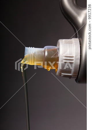 Can with car engine oil pouring black background 9917236