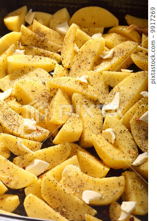 Raw potatoes with spices ready to be roasted Raw potatoes with spices ready to be roasted 9917269