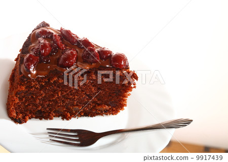 Piece of chocolate cake with icing and cherry Piece of chocolate cake with icing and cherry 9917439