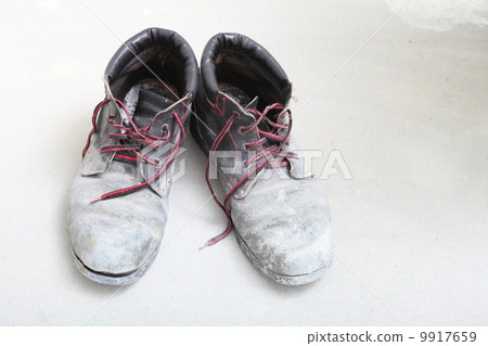 pair of old dirty work boots in building site pair of old dirty work boots in building site 9917659